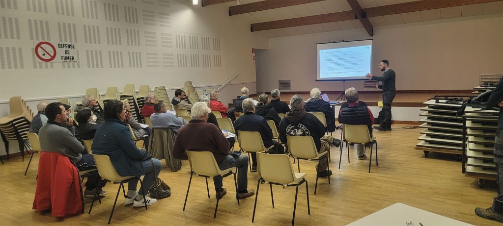 Réunion de sensibilisation. Un intervenant s'adresse à une audience.